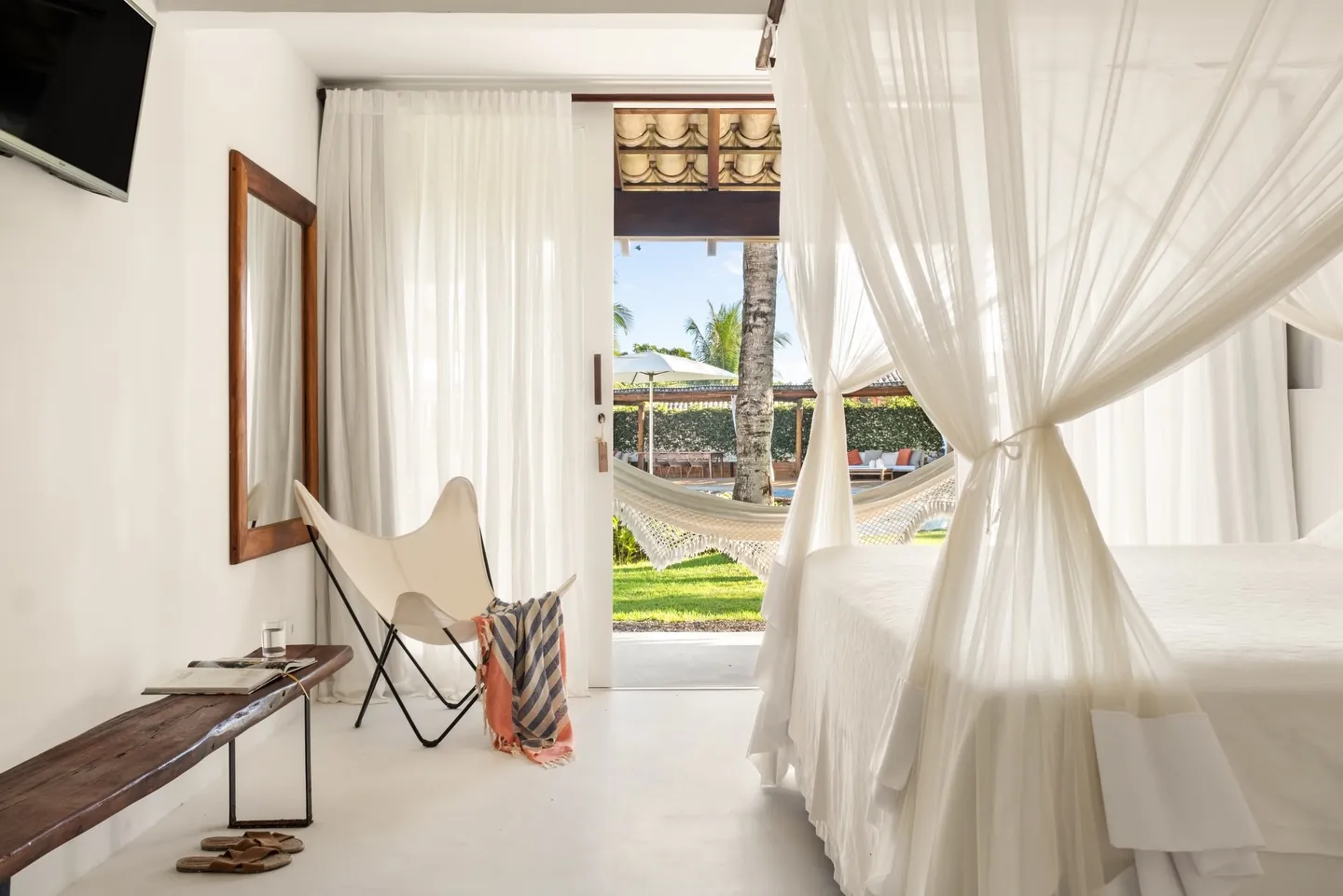 Suíte do Brisas com cama de mosquiteiro e porta para o jardim